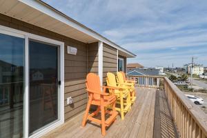 a deck with four chairs on a house at 4740 - August's Summer Place in Kitty Hawk Beach