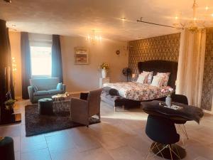 a bedroom with a bed and a living room at Gasterij Hotel Dennenoord in Boxtel +72 photos