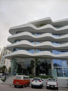 a building with cars parked in front of it at Park Life Nautico in Nuevo Vallarta