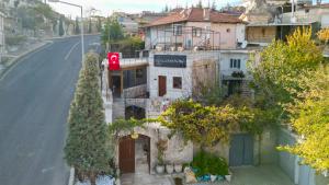 a building on the side of a road with trees at Lubberona Cave Cappadocia in Nar