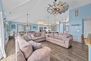 a living room with two couches and a dining room at 1090 - Catch Me N Corolla in Corolla