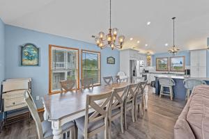 a dining room and kitchen with a table and chairs at 1090 - Catch Me N Corolla in Corolla