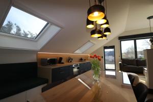 a kitchen and dining room with a table and windows at Chez Martine & Pierre in Baillonville