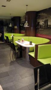 a dining room with green chairs and a table at km24 ALBERGUE in Padrón