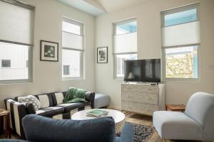 a living room with a couch and a tv at Blue Crest Architectural Treehouse Retreat in Ocean Springs