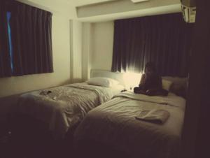 a girl sitting on a bed in a hotel room at Alojarte SAI in Estación El Salto