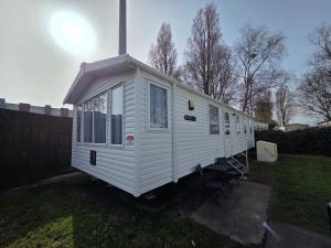 a white tiny house sitting in a yard at Poole Rockley Park Dorset in Poole