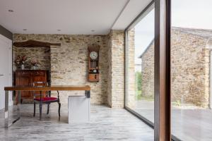 a dining room with a table and a brick wall at A Finca Hotel in Barreiros