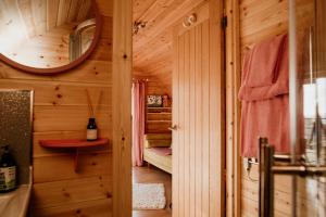 a wooden cabin with a bed and a mirror at The Sleepy Crofter Glamping - Achiltibuie in Achiltibuie +191 photos