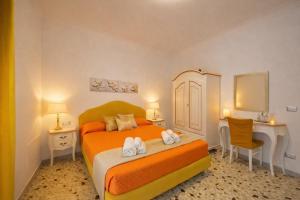 a bedroom with a bed and a desk and a mirror at Floral Holiday in Minori
