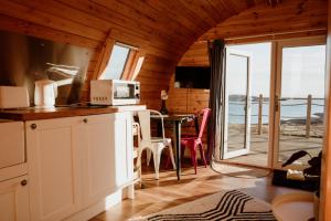 a kitchen with a table with a microwave and a balcony at The Sleepy Crofter Glamping - Achiltibuie in Achiltibuie