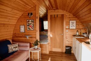 a living room with a couch in a wooden cabin at The Sleepy Crofter Glamping - Achiltibuie in Achiltibuie