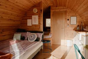 a room with a bed in a wooden cabin at The Sleepy Crofter Glamping - Achiltibuie in Achiltibuie