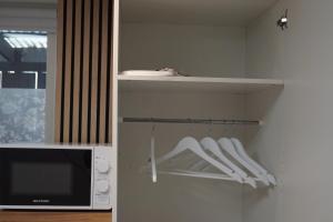 a kitchen with a microwave and a shelf with white utensils at BRABO in Landskrona