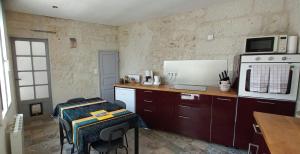 a small kitchen with a counter and a microwave at La troglo aux oiseaux in Montrichard