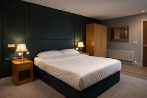 a bedroom with a large bed and two lamps at Donegal Manor in Donegal