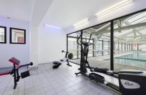 a gym with several exercise bikes and a swimming pool at Le Mazet du Mont Ventoux in Malaucène