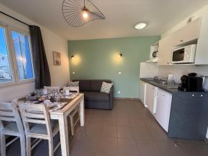 a kitchen and living room with a table and a couch at Le Mazet du Mont Ventoux in Malaucène