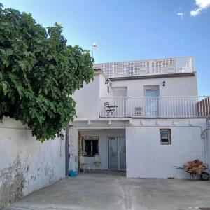 a white house with a balcony on top of it at Alojamiento Peña Dorada in Lumpiaque