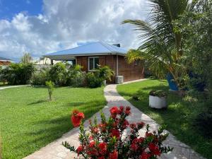 a house with a garden with flowers in front of it at Coin tranquille in Sainte-Anne