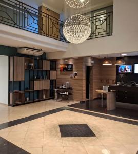 a lobby with a television and a table and a chandelier at O Melhor Apart-Hotel da Cidade! Estacione Grátis in São Caetano do Sul