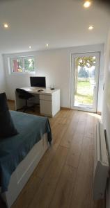 a bedroom with a bed and a desk with a computer at La troglo aux oiseaux in Montrichard