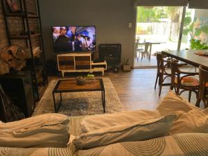 a living room with a couch and a tv at Casa Los Nogales in Roldán