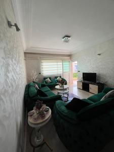 a living room with two green couches and a television at DreamCatcher ocean in Mohammedia