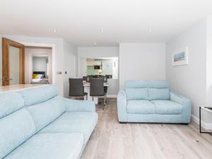 a living room with a blue couch and a chair at Apartment 19 in Newquay