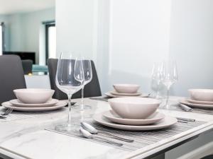 a table with plates and wine glasses on it at Apartment 19 in Newquay