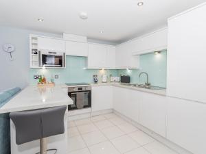a kitchen with white cabinets and a counter top at Apartment 19 in Newquay