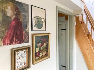 a group of paintings on a wall in a room at 11 The Plosh in Keswick