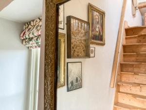 a mirror hanging on a wall with framed pictures at 11 The Plosh in Keswick