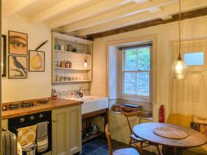 a kitchen with a sink and a table and a window at 11 The Plosh in Keswick
