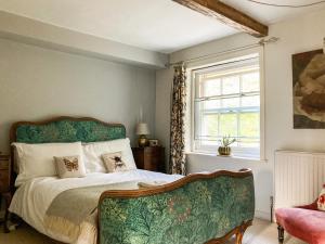 a bedroom with a bed and a chair at 11 The Plosh in Keswick