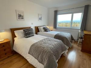 two beds in a bedroom with a window at Erne View Lodge in Lisnaskea
