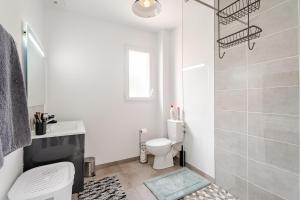 a white bathroom with a toilet and a shower at la pause detente, villa climatisée avec jardin et parking privés, à 5 mn de la mer, au calme in Martigues +23 photos