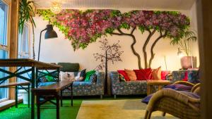 a living room with a tree painted on the wall at Igloo Hybrid in Nottingham