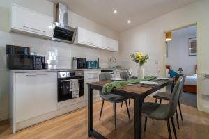 a kitchen with a table and chairs in a room at Vantage Stays in Gloucester +9 photos