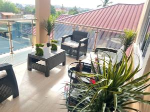 a balcony with chairs and a table and plants at Chameleon Luxury Apartment in Trofwi