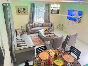 a living room with a couch and a table at Chameleon Luxury Apartment in Trofwi