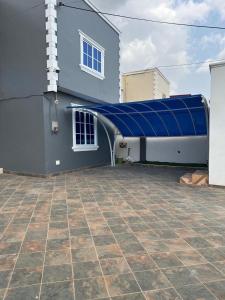 a building with a blue cover on the side of it at Chameleon Luxury Apartment in Trofwi