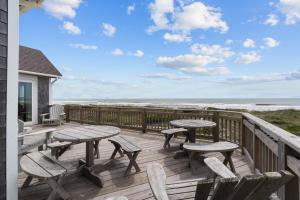 a deck with picnic tables and chairs and the beach at 7865 - Peridot in Frisco +37 photos