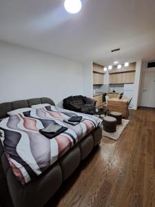 a bedroom with a large bed and a living room at Tea Planet 2 in Niš