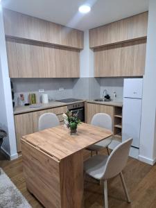 a kitchen with a wooden table and chairs at Tea Planet 2 in Niš