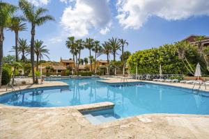 a large swimming pool with palm trees in the background at Aura de Mar - Dúplex boutique cerca de la playa in Son Xoriguer
