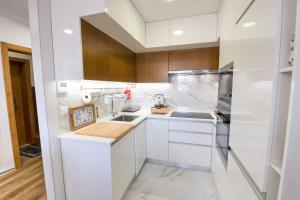 a kitchen with white cabinets and wooden walls at Lendalima Formosa in Ponte de Lima