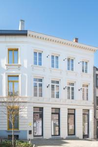 a white building with many windows on a street at The Librarian by Domani Hotels in Ghent