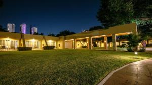 a building with a green lawn in front of it at night at Camino Real Guadalajara in Guadalajara