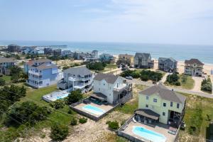 an aerial view of a neighborhood with houses and the ocean at 7676 - Nautical by Nature in Avon
